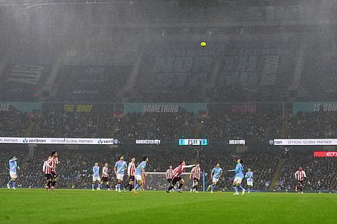 Rain falls during the English League Cup soccer match between Manchester City and Brentford in Manchester, England.