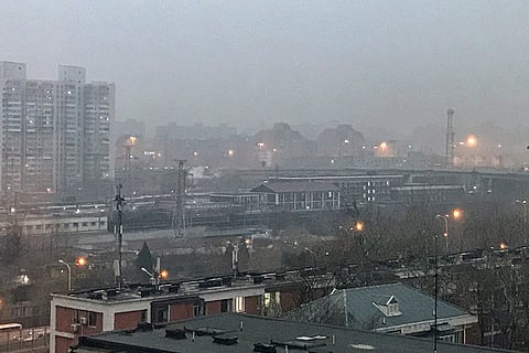 Smog shrouds residential high-rises and railway tracks as air pollution reduces visibility in the city, in Beijing, China.