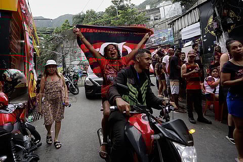 Fans of Brazil's Flamengo soccer club cheer in the Rocinha favela of Rio de Janeiro prior to their team's FIFA Intercontinental Cup final soccer match against Paris Saint-Germain in Doha, Qatar. 