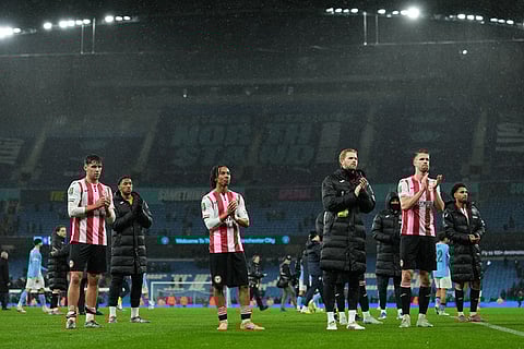 Brentford's players applaud fans after the English League Cup soccer match between Manchester City and Brentford in Manchester, England.
