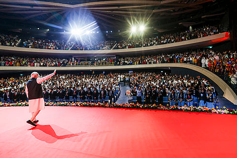 Prime Minister Narendra Modi waves to the members of the Indian community during the Maitri Parv program, in Muscat, Oman. 