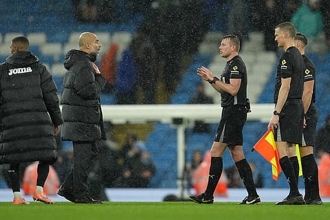 Manchester City's head coach Pep Guardiola speaks to the referees after the English League Cup soccer match between Manchester City and Brentford in Manchester, England.