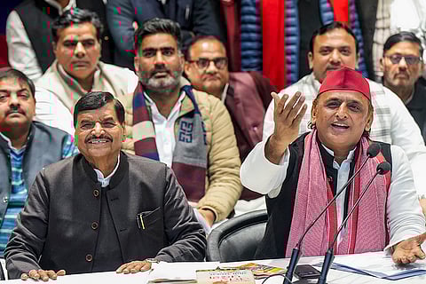 Samajwadi Party President Akhilesh Yadav, right, addresses a press conference, at party office in Lucknow.