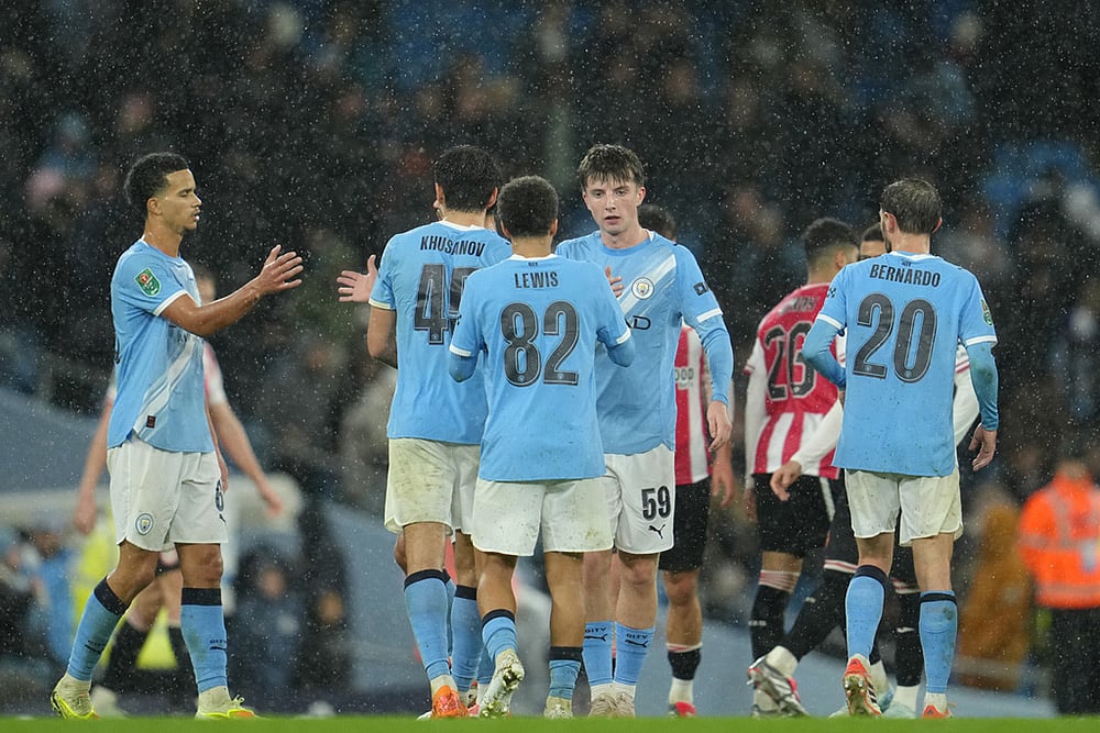 Manchester City's Rico Lewis shakes hands with Manchester City's Charlie Gray after the English League Cup soccer match between Manchester City and Brentford in Manchester, England. - | Photo: AP/Jon Super