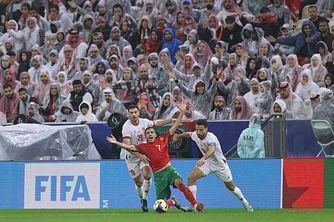 Morocco's Mohamed Boulacsout, center, battles for the ball with Jordan's Mohannad Abutaha, left, and Mahmoud Almardi during to the FIFA Arab Cup final soccer match between Jordan and Morocco in Lusail, Qatar.