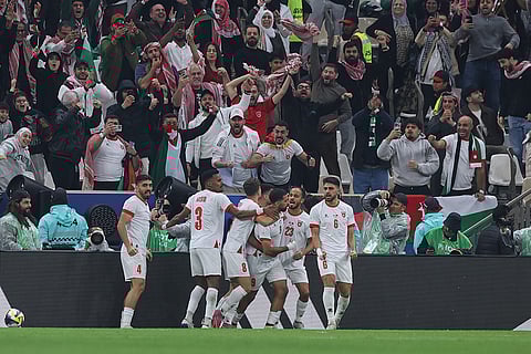 Jordan's Ali Olwan, center, celebrates with teammates after scoring their side's first goal during to the FIFA Arab Cup final soccer match between Jordan and Morocco in Lusail, Qatar.