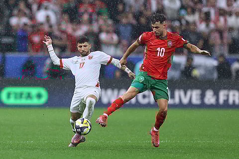 Morocco's Amin Zahzouh, right, battles for the ball with Jordan's Issam Smeeri during to the FIFA Arab Cup final soccer match between Jordan and Morocco in Lusail, Qatar.
