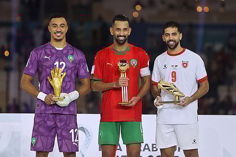 From left, Morocco's goalkeeper El Mehdi Benabid, best goalkeeper, Morocco's Mohamed Rabie Hrimat, best player, and Jordan's Ali Olwan, top scorer, pose with their trophies during a trophy ceremony end of the FIFA Arab Cup final soccer match between Morocco and Jordan, in Lusail, Qatar.