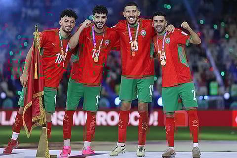 From left, Morocco's players Amin Zahzouh, Azaro Oualid, Saadane Marwane and El Berkaoiui Karim celebrate at the podium after defeating Jordan in the FIFA Arab Cup final soccer match, in Lusail, Qatar.