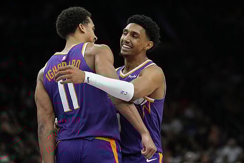 Phoenix Suns forward Ryan Dunn, right, smiles as he celebrates his score against the Golden State Warriors with Suns forward Oso Ighodaro (11) during the second half of an NBA basketball game in Phoenix. 