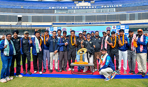 Jharkhand cricket team's captain Ishan Kishan, centre, and teammates pose with the trophy during celebrations after the team won the Syed Mushtaq Ali Trophy 2025, at JSCA International Stadium, in Ranchi.