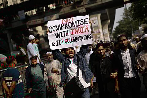 A protester holds a placard and shout slogans during a protest following overnight attacks and vandalism after the death of a prominent activist, who was shot by an assailant a week ago, in Dhaka, Bangladesh.