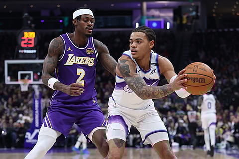 Utah Jazz guard Keyonte George, right, looks for a play against Los Angeles Lakers forward Jarred Vanderbilt (2) during the first quarter of an NBA basketball game in Salt Lake City. 