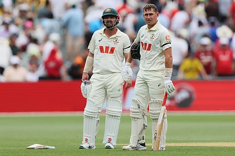 Australia's Marnus Labuschagne, right, awaits for the result of a video review to confirm his dismissal as he stands with teammate Travis Head, left, during play on day three of the third Ashes cricket test between England and Australia in Adelaide, Australia.