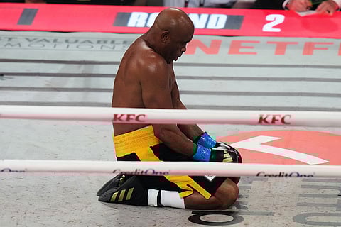 Anderson Silva kneels on the canvas after being hit by Tyron Woodley during their cruiserweight fight in Miami.