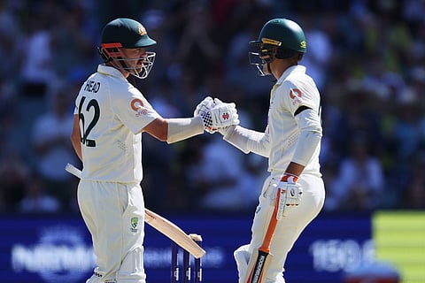 Australia's Alex Carey congratulates teammate Travis Head, left, on reaching a 150 runs during play on day four of the third Ashes cricket test between England and Australia in Adelaide, Australia.