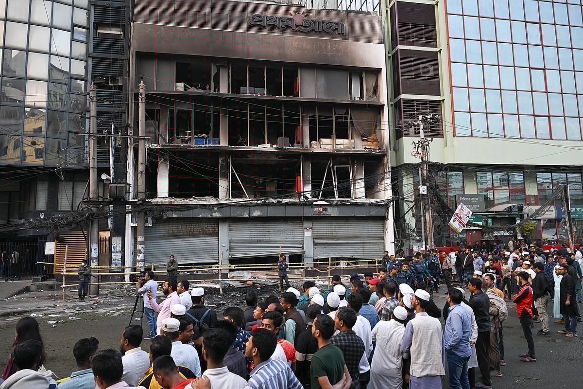 People eager to see the aftermath of the attack, vandalism, and arson incident gather in front of the Prothom Alo office building in Karwan Bazar. Violence broke out in Dhaka following the death of youth leader Sharif Osman Hadi, a key figure in Bangladesh™s 2024 pro-democracy uprising, who died in Singapore from injuries sustained in an assassination attempt.  - IMAGO / ZUMA Press Wire