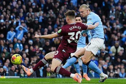 Manchester City's Erling Haaland, right, scores the opening goal during the English Premier League soccer match between Manchester City and West Ham United in Manchester, England.