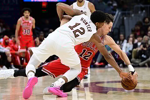 Cleveland Cavaliers forward De'Andre Hunter and Chicago Bulls forward Zach Collins battle for a loose ball in the second half of an NBA basketball game in Cleveland. 