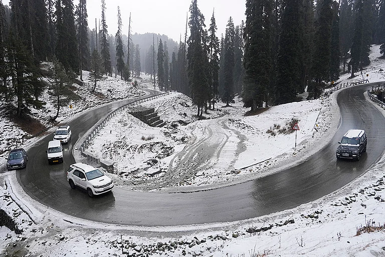 Vehicles pass through a snow-covered valley after fresh snowfall on the first day of ‘Chillai Kalan’, in Gulmarg, Baramulla district, Jammu and Kashmir. ‘Chillai Kalan’ is a 40-day harsh winter period in Kashmir which begins on December 21 every year and ends on January 31. - | Photo: PTI/S Irfan