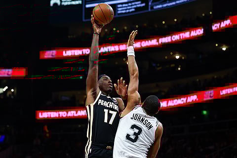 Atlanta Hawks forward Onyeka Okongwu (17) looks to shoot over San Antonio Spurs forward Keldon Johnson (3) during the first half of an NBA basketball game, in Atlanta. 