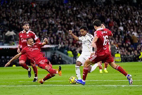 Real Madrid's Fran Garcia, center is tackled by Sevilla's Djibril Sow, left, during the Spanish La Liga soccer match between Real Madrid and Sevilla in Madrid, Spain.