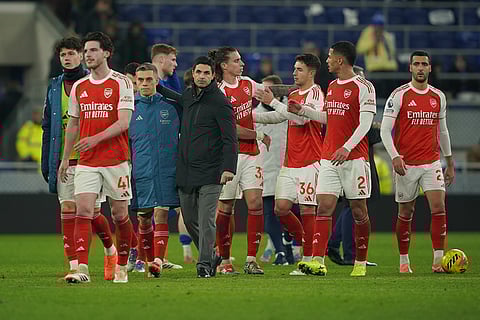 Arsenal's manager Mikel Arteta, fourth from left, and his players celebrate after the English Premier League soccer match between Everton and Arsenal in Liverpool, England.