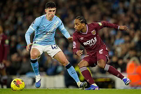 Manchester City's Phil Foden, left vies for the ball with West Ham's Kyle Walker-Peters during the English Premier League soccer match between Manchester City and West Ham United in Manchester, England.