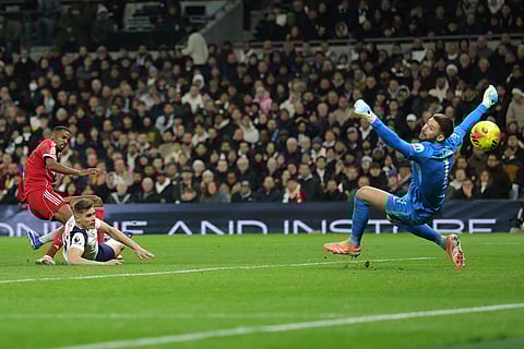 Liverpool's Alexander Isak, left, scores the opening goal during the English Premier League soccer match between Tottenham and Liverpool in London.
