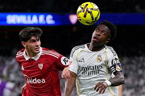 Real Madrid's Vinicius Junior, right looks to control the ball under pressure from Sevilla's Juanlu Sanchez during the Spanish La Liga soccer match between Real Madrid and Sevilla in Madrid, Spain.