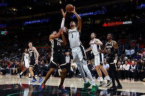 San Antonio Spurs forward Victor Wembanyama (1) looks to shoot against Atlanta Hawks forward Asa Newell (14) during the second half of an NBA basketball game in Atlanta. 