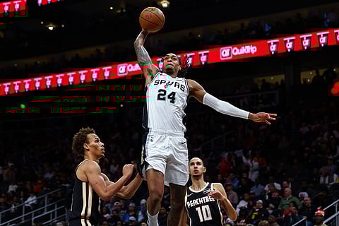 San Antonio Spurs guard Devin Vassell (24) goes up to dunk over Atlanta Hawks guard Dyson Daniels, left, during the second half of an NBA basketball game in Atlanta. 
