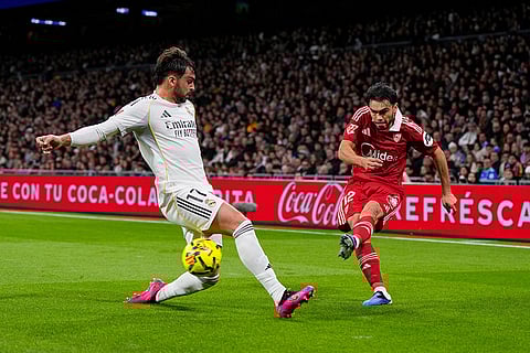 Sevilla's Gabriel Suazo, right, crosses the ball as Real Madrid's Raul Asencio attempts to block during the Spanish La Liga soccer match between Real Madrid and Sevilla in Madrid, Spain.
