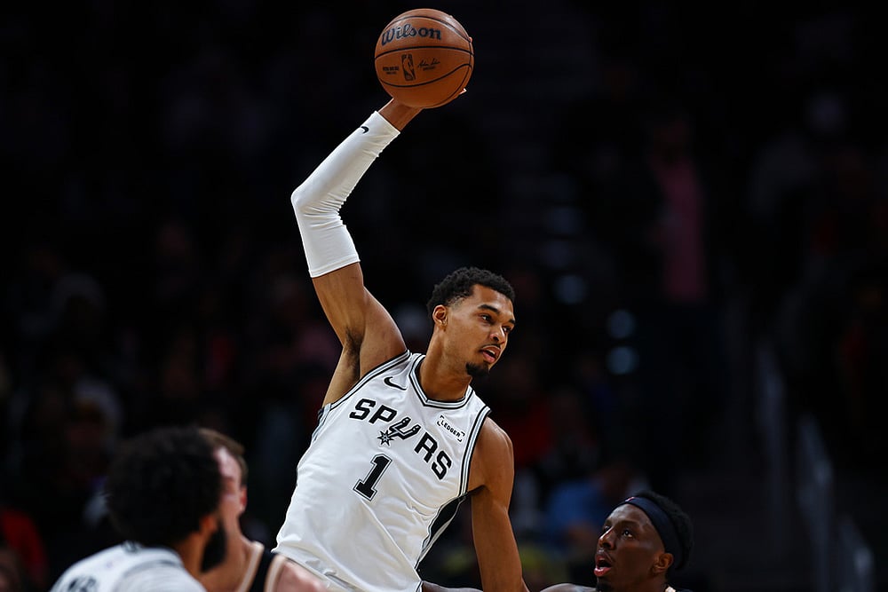 San Antonio Spurs forward Victor Wembanyama (1), grabs a pass over Atlanta Hawks forward Onyeka Okongwu, right, during the first half of an NBA basketball game in Atlanta.  - | Photo: AP/Colin Hubbard