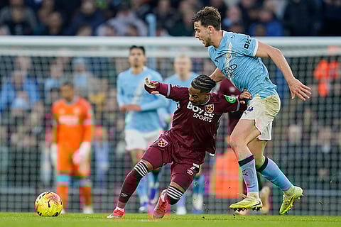 West Ham's Crysencio Summerville, left, fends off the tackle of Manchester City's Nico Gonzalez,during the English Premier League soccer match between Manchester City and West Ham United in Manchester, England.
