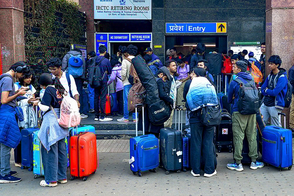Passengers arrive at the Ranchi railway station amid train delays and cancellations caused by fog on a winter morning, in Ranchi. - | Photo: PTI