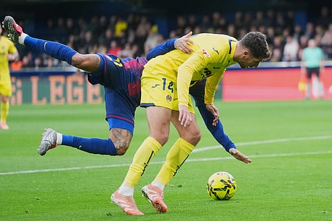 Barcelona's Raphinha, left, is tackled by Villarreal's Santi Comesana during the Spanish La Liga soccer match between Villarreal and Barcelona in Villarreal, Spain.