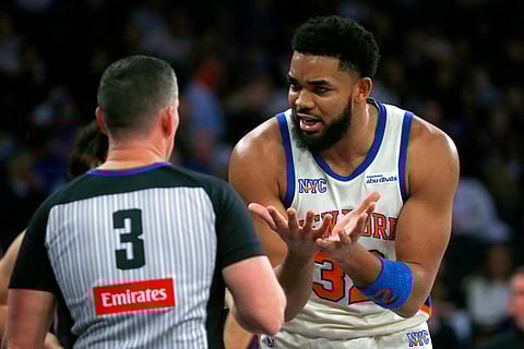 New York Knicks center Karl-Anthony Towns argues with referee Nick Buchert during the first half of an NBA basketball game against the Miami Heat, in New York. 