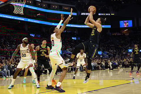 Golden State Warriors guard Stephen Curry (30) shoots against Phoenix Suns forward Ryan Dunn (0) during the second half of an NBA basketball game in San Francisco.