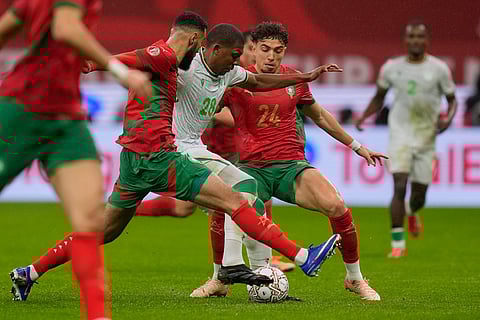 Comoros' Youssouf Zaydou in action between Morocco's Noussair Mazraoui , left, and Neil Yoni El Aynaoui during the Africa Cup of Nations group A soccer match between Morocco and Comoros in Rabat, Morocco.