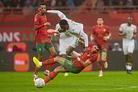 Morocco 2-0 Comoros, AFCON 2025: El Kaabi Screamer Seals Winning Start For Hosts | Photo: AP/Mosa'ab Elshamy : Morocco's Jawad El Yamiq tackles Comoros' Rafiki Saïd Ahamada during the Africa Cup of Nations group A soccer match between Morocco and Comoros in Rabat, Morocco.