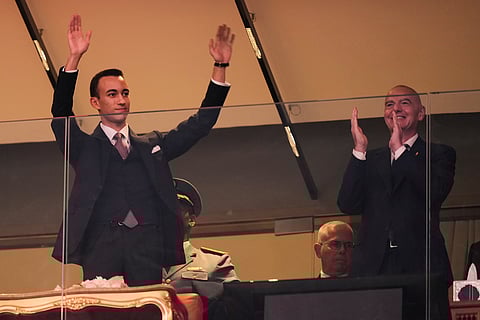 Moulay Hassan, Crown Prince of Morocco, waves while FIFA President Gianni Infantino applauds before the Africa Cup of Nations group A soccer match between Morocco and Comoros in Rabat, Morocco.