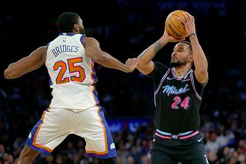 Miami Heat guard Norman Powel (24) looks to shoot over New York Knicks guard Mikal Bridges (25) during the second half of an NBA basketball game in New York. 