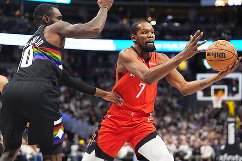 Houston Rockets forward Kevin Durant, right, pulls in a loose ball as Denver Nuggets guard Tim Hardaway Jr. defends in the second half of an NBA basketball game in Denver.