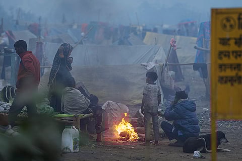 People warm themselves near a makeshift fire on a cold winter morning, in New Delhi.