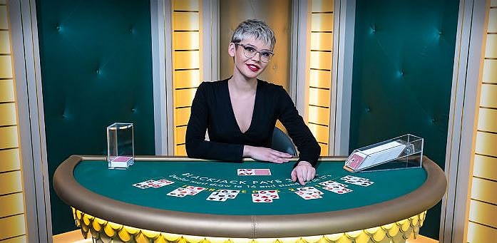 A female dealer dealing a game of blackjack at a casino table