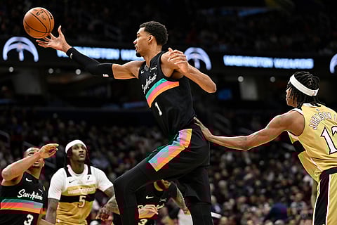 San Antonio Spurs forward Victor Wembanyama (1) grabs a rebound over Washington Wizards guard Tre Johnson, right, during the first half of an NBA basketball game in Washington.