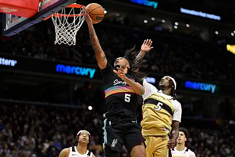 San Antonio Spurs guard Stephon Castle, top left, scores against Washington Wizards guard Jamir Watkins, top right, during the second half of an NBA basketball game in Washington. 