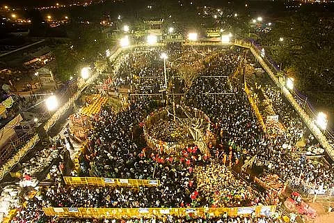 Crowded outdoor night festival under bright lights