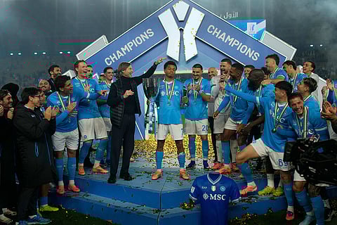 Napoli's David Neres holds the trophy at the end of the Italian Super Cup final soccer match between Napoli and Bologna in Riyadh, Saudi Arabia.
